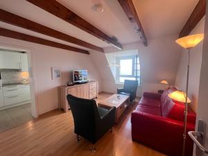 a living room with a red couch and a table at Nordland Appartements - Wohnung Alsen in Wyk auf Föhr