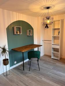 uma sala de jantar com uma mesa e uma parede verde em YellowHouse - Teleworking- Wifi - CosyHouseByJanna em Châtellerault