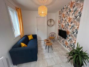 uma sala de estar com um sofá azul e uma mesa em YellowHouse - Teleworking- Wifi - CosyHouseByJanna em Châtellerault
