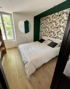 a bedroom with a white bed with a green wall at Haut standing (50m²) - Cholet Centre in Cholet