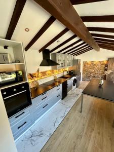 a large kitchen with white cabinets and marble counter tops at Haut standing (50m²) - Cholet Centre in Cholet