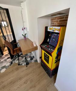 um quarto com uma máquina de jogos de vídeo ao lado de uma mesa em Haut standing (50m²) - Cholet Centre em Cholet