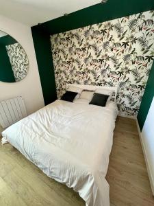 a bedroom with a white bed with a wall at Haut standing (50m²) - Cholet Centre in Cholet