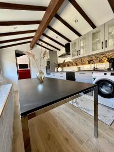 uma cozinha com uma mesa preta no meio em Haut standing (50m²) - Cholet Centre em Cholet