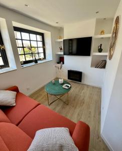 a living room with a red couch and a table at Haut standing (50m²) - Cholet Centre in Cholet