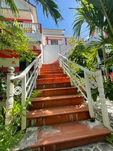a staircase leading up to a building with trees at Red House Homestay - Villa in Hoi An