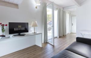 a living room with a couch and a tv and a mirror at Rimini Suite Hotel in Rimini