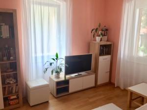 een woonkamer met een flatscreen-tv op een standaard bij Harmony I in Opatija
