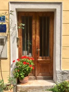 een houten deur met een pot bloemen ervoor bij Harmony I in Opatija