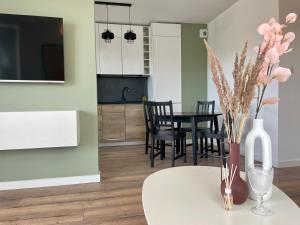 une cuisine et un salon avec une table et des chaises dans l'établissement Calm Apartment nr 8, à Olsztyn