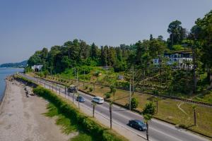 a road with cars on it next to a river at House at the Sea in Batumi