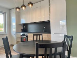 a kitchen with a table and chairs in a kitchen at Calm Apartment nr 8 in Olsztyn