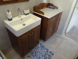 La salle de bains est pourvue d'un lavabo blanc et d'une douche. dans l'établissement AEGEAN VISTA, à Batsi