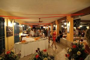 a group of people walking around a restaurant with tables at Villaggio Piscina Rei in Monte Nai