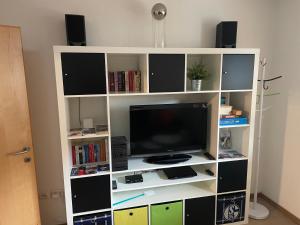 ein weißes Bücherregal mit einem TV und Lautsprechern in der Unterkunft Appartement Luna in Mittersill