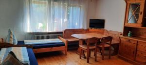 ein Wohnzimmer mit einem Tisch, Stühlen und einem Bett in der Unterkunft helle Souterrainwohnung nähe Flughafen, Landshut und München 1 bis 5 Personen in Bruckberg