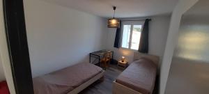 a small room with a bed and a window at La Grangette du Mas in Chassiers