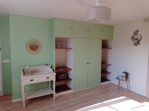 Saint-Hilaire-la-Palud的住宿－AU COEUR DU MARAIS，一间设有绿色橱柜和一张书桌的房间