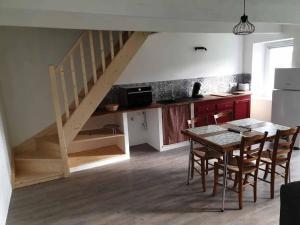 uma cozinha com uma mesa de jantar e uma escada em Logements Bonne Nouvelle em Rostrenen