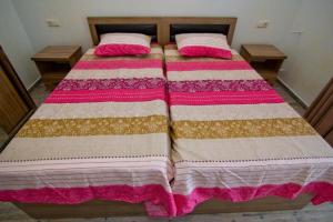 a bedroom with two beds with pink and white blankets at Apartments Georgia in Makhinjauri