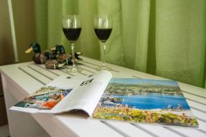 a table with two glasses of wine and a magazine at Stathopoulos Apartments in Sampatiki