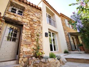 a stone house with a gate and a garage at Pretty Historical Village House in Grimaud