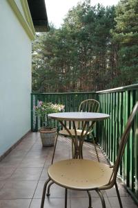 een tafel en 2 stoelen op een balkon bij Dworek Drawa in Drezdenko