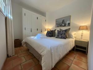 a bedroom with a white bed with two pillows at Pretty Historical Village House in Grimaud