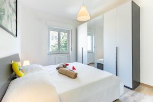 ミラノにあるALESSIA'S FLAT - MILANO 3のベッドルーム1室(白いベッド1台、動物2匹の詰め物付)