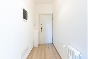 un corridoio con porta bianca e pavimento in legno di ALESSIA'S FLAT - MILANO 3 a Milano
