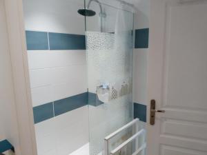 a shower with blue and white stripes in a bathroom at GITE DE CHARME SUR LA COTE D'ALBATRE in Saint-Aubin-sur-Mer