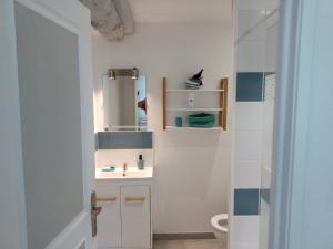 a white bathroom with a sink and a toilet at GITE DE CHARME SUR LA COTE D'ALBATRE in Saint-Aubin-sur-Mer