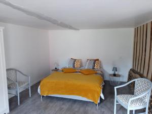 a bedroom with a bed and two chairs at GITE DE CHARME SUR LA COTE D'ALBATRE in Saint-Aubin-sur-Mer