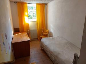 Un dormitorio con una cama y un escritorio y una ventana. en Fewo Leezdorf, en Leezdorf