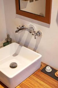 lavabo blanco en el baño con espejo en Full Apartment in the Heart of Roma Neighborhood, en Ciudad de México