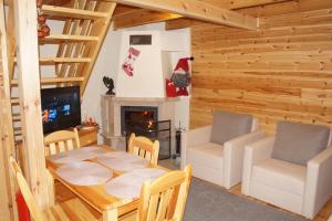 a living room with a table and chairs and a fireplace at Domki Muszelka in Stegna
