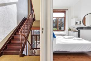 a bedroom with a bed and a staircase at The Old One Fifteen by Romy&Travis in Ghent