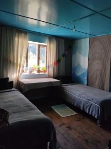 - une chambre avec 2 lits jumeaux et une fenêtre dans l'établissement Panorama Inn Mustang, à Muktināth