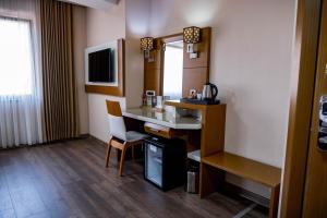Habitación de hotel con escritorio y espejo en Selçuk Hotel en Konya