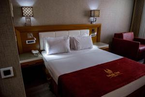 コンヤにあるSelçuk Hotelの大きなベッドと椅子が備わるホテルルームです。