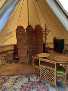 a tent with chairs and a table in a room at Glamping De Vrije Wind, Tentverhuur in Houwerzijl