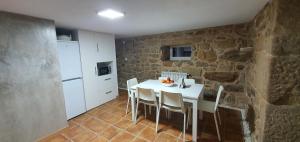 a kitchen and dining room with a white table and chairs at Casa Pinto - AL in Valença