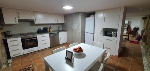 a kitchen with a table with a bowl of fruit on it at Casa Pinto - AL in Valença +43 photos