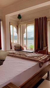 ein großes Bett in einem Zimmer mit einem großen Fenster in der Unterkunft Peacock Paying Guest House in Udaipur