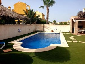 ein Schwimmbad in einem Hof neben einem Haus in der Unterkunft Villa Preciosa Piscina Climatizada in Mazarrón