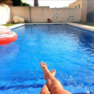 osoba leżąca na boku basenu w obiekcie Villa Preciosa Piscina Climatizada w mieście Mazarrón