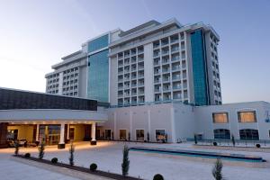 a large building with a pool in front of it at ALUSSO THERMAL HOTEL SPA in Afyon