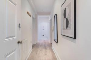 a hallway with white walls and white doors and wood floors at One Bedroom - Tower Bridge - London City by Prime London Stays M-10 in London