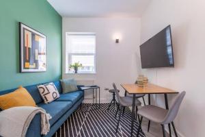 a living room with a blue couch and a table at One Bedroom - Tower Bridge - London City by Prime London Stays M-10 in London