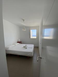 a white room with a bed and a window at CERRO NEGRO Bergantin in Las Negras